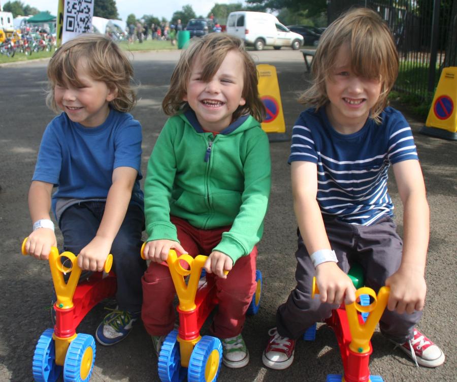 Three happy children on tricycles