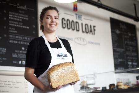 The Good Loaf woman serving a freshly baked loaf