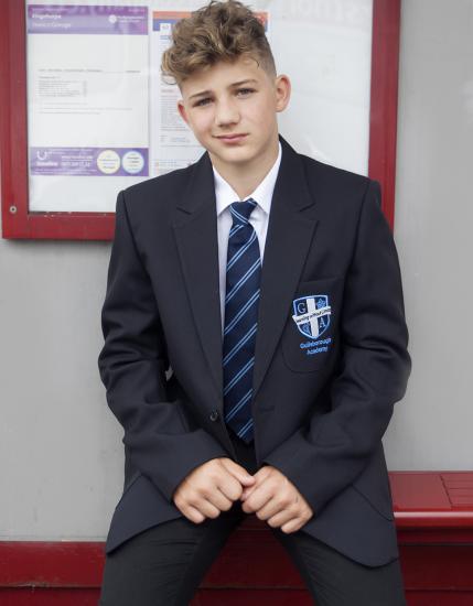 School boy sitting at bus stop