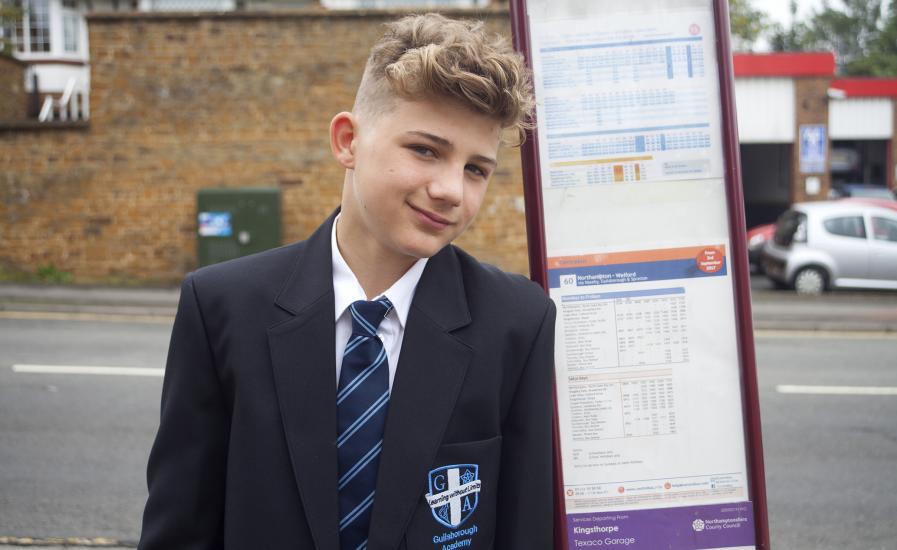 School boy next to bus timetable