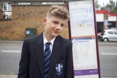 School boy next to bus timetable